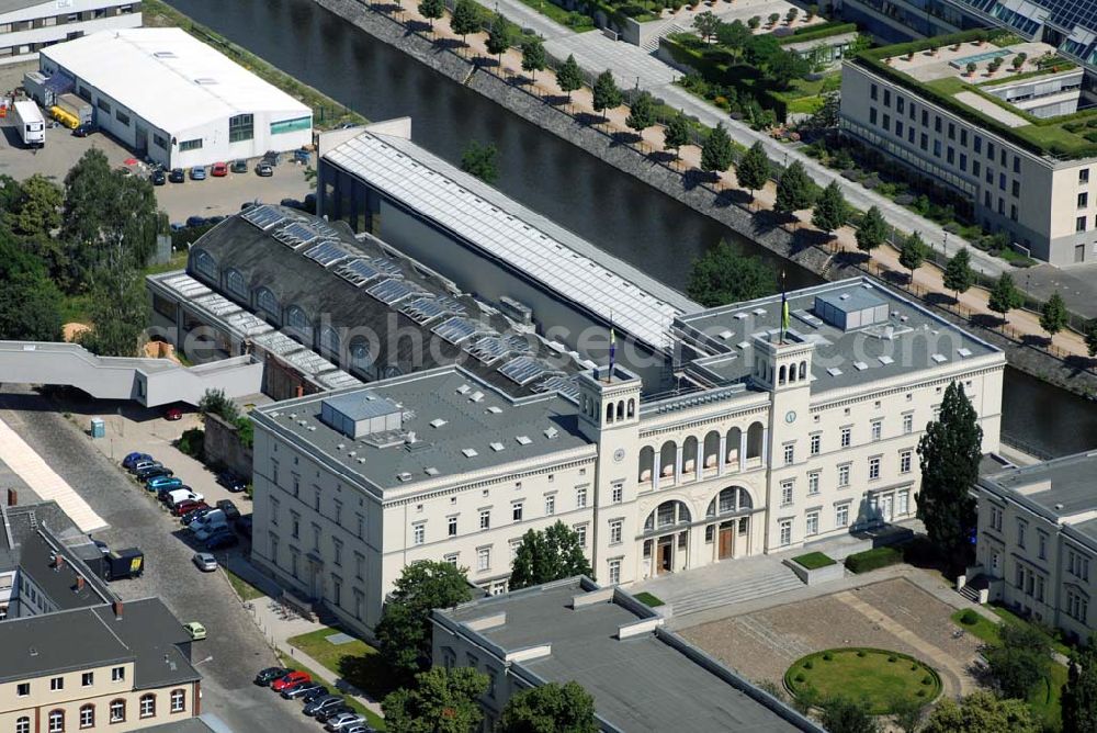 Berlin from above - . 1841 wurde per Staatsvertrag der Bau einer Eisenbahnlinie zwischen den beiden größten deutschen Städten beschlossen, 1846 begann die Jungfernfahrt nach Hamburg in einem Berliner Güterschuppen - der Bahnhof war noch im Bau. Die Arbeiten waren mit beträchtlichen technischen Schwierigkeiten verbunden: Der moorige Baugrund mußte durch Sand aufgeschüttet werden, dazu wurde der Spreekanal nach Norden verlegt. Um das entstehende Schienennetz an die Wasserstraßen anzubinden, legte man gleichzeitig bis 1859 den Spandauer Schifffahrtskanal und den Humboldthafen an. Der Bahnhof selbst entstand in einjähriger Bauzeit bis 1847. 1884, nur 37 Jahre nach seiner Eröffnung, wurde der Bahnhof stillgelegt. 1906 richtete man das Verkehrs- und Baumuseum ein, für das 1911 bis 1916 zwei Flügel zur Straße hin angebaut wurden, wodurch der heutige Ehrenhof entstand. Den Umbau für das 1996 eröffnete Museum für Gegenwart leitete Josef Paul Kleihues. Von ihm stammt auch der rechts der großen Halle gelegene, 80 Meter lange Erweiterungsbau