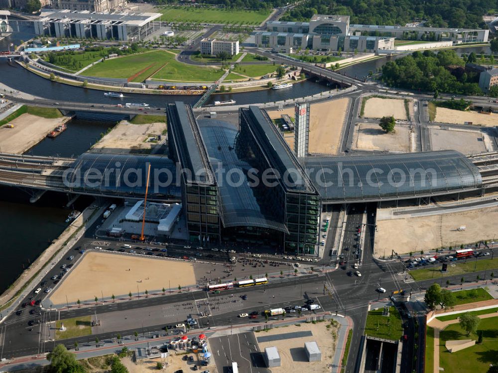 Aerial photograph Berlin - The Central Station is the most important railway junction in the capital. The distinctive building was designed by architect Meinhard von Gerkan. The station building has two main levels, which serve the railways, and three connections and business levels. The station includes expanses and is therefore a major commercial real estate