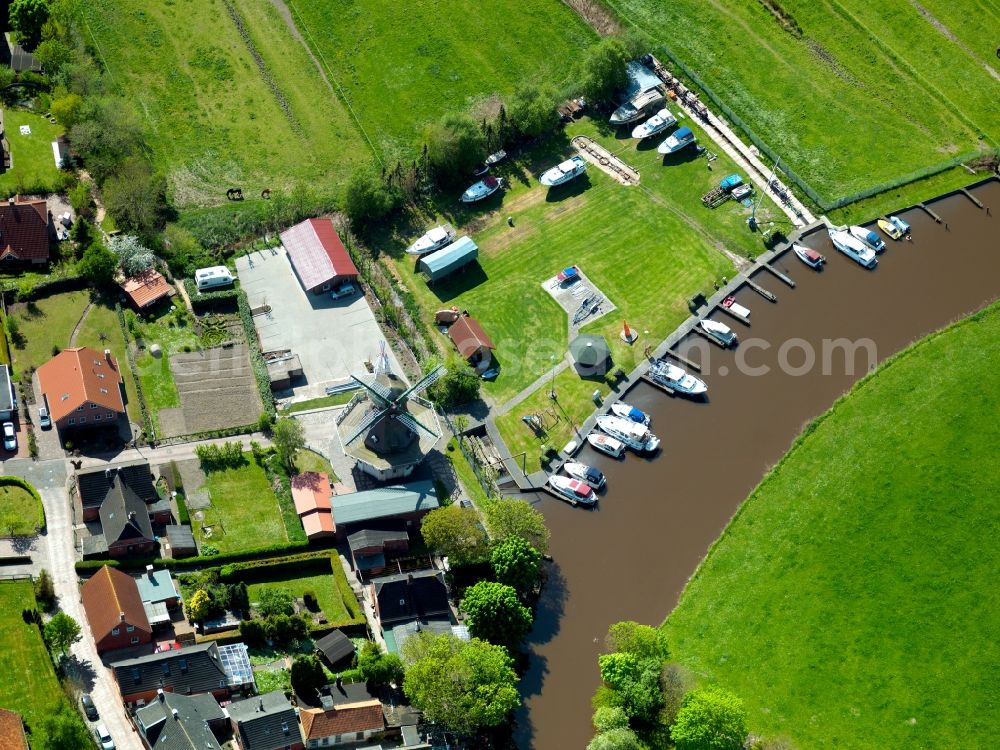 Emden from the bird's eye view: The yacht port and the windmill in the Larrelt part of the city of Emden in the state of Lower Saxony. The compound is located on a channel in the west of the city. The windmill Kost Winning is on site since 1732 and is today run by the Larrelter Dorfverein - a community project and association