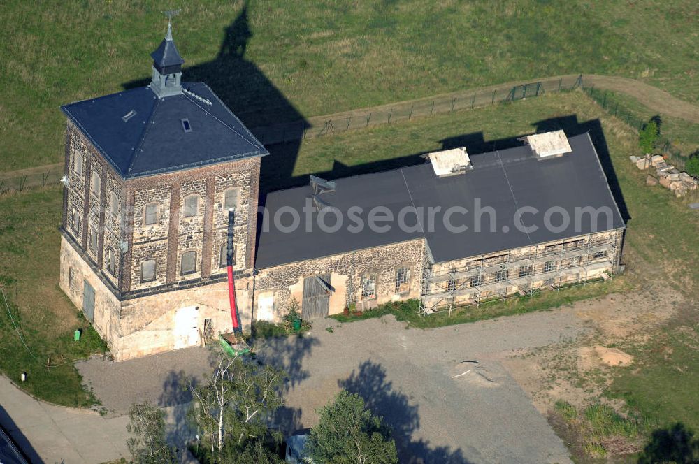 Aerial image Bannewitz - Blick auf den Marienschacht. Der Marienschacht ist ein ehemaliges Steinkohlebergwerk in der Gemeinde Bannewitz. Er bildet ein bergbauhistorisches Ensemble. Die Freiherrlich von Burgker Steinkohlewerke teuften den Schacht zwischen 1886 und 1893 ab, wobei man in etwa 545 m Teufe auf das Hauptsteinkohleflöz von ca. 6 m Mächtigkeit traf. 1930 wurde der Betrieb eingestellt. In der DDR wurde die Steinkohlenförderung wieder aufgenommen, diesmal als Schacht des VEB Steinkohlenwerks „Willi Agatz“. Da die Kohlen einen Urangehalt von ca. 0,3% aufwiesen, übernahm 1968 die SDAG Wismut die Kohlenförderung, um daraus Uran zu gewinnen. 1989 wurde der Schacht endgültig stillgelegt, zurückgebaut und mit Halde bis 1999 durch die Wismut GmbH saniert.Der markante, 1891 errichtete Förderturm, heute ein technisches Denkmal, ist ein im deutschen Raum eher seltener so genannter Malakow-Turm und der zuletzt errichtete seiner Bauart in Deutschland. In den 1960er Jahren wurde eine Kaue angebaut.