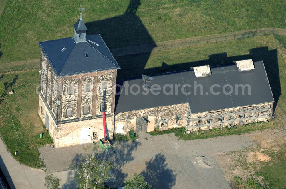 Bannewitz from above - Blick auf den Marienschacht. Der Marienschacht ist ein ehemaliges Steinkohlebergwerk in der Gemeinde Bannewitz. Er bildet ein bergbauhistorisches Ensemble. Die Freiherrlich von Burgker Steinkohlewerke teuften den Schacht zwischen 1886 und 1893 ab, wobei man in etwa 545 m Teufe auf das Hauptsteinkohleflöz von ca. 6 m Mächtigkeit traf. 1930 wurde der Betrieb eingestellt. In der DDR wurde die Steinkohlenförderung wieder aufgenommen, diesmal als Schacht des VEB Steinkohlenwerks „Willi Agatz“. Da die Kohlen einen Urangehalt von ca. 0,3% aufwiesen, übernahm 1968 die SDAG Wismut die Kohlenförderung, um daraus Uran zu gewinnen. 1989 wurde der Schacht endgültig stillgelegt, zurückgebaut und mit Halde bis 1999 durch die Wismut GmbH saniert.Der markante, 1891 errichtete Förderturm, heute ein technisches Denkmal, ist ein im deutschen Raum eher seltener so genannter Malakow-Turm und der zuletzt errichtete seiner Bauart in Deutschland. In den 1960er Jahren wurde eine Kaue angebaut.