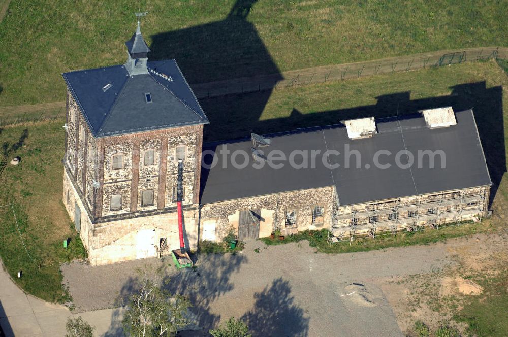 Bannewitz from the bird's eye view: Blick auf den Marienschacht. Der Marienschacht ist ein ehemaliges Steinkohlebergwerk in der Gemeinde Bannewitz. Er bildet ein bergbauhistorisches Ensemble. Die Freiherrlich von Burgker Steinkohlewerke teuften den Schacht zwischen 1886 und 1893 ab, wobei man in etwa 545 m Teufe auf das Hauptsteinkohleflöz von ca. 6 m Mächtigkeit traf. 1930 wurde der Betrieb eingestellt. In der DDR wurde die Steinkohlenförderung wieder aufgenommen, diesmal als Schacht des VEB Steinkohlenwerks „Willi Agatz“. Da die Kohlen einen Urangehalt von ca. 0,3% aufwiesen, übernahm 1968 die SDAG Wismut die Kohlenförderung, um daraus Uran zu gewinnen. 1989 wurde der Schacht endgültig stillgelegt, zurückgebaut und mit Halde bis 1999 durch die Wismut GmbH saniert.Der markante, 1891 errichtete Förderturm, heute ein technisches Denkmal, ist ein im deutschen Raum eher seltener so genannter Malakow-Turm und der zuletzt errichtete seiner Bauart in Deutschland. In den 1960er Jahren wurde eine Kaue angebaut.