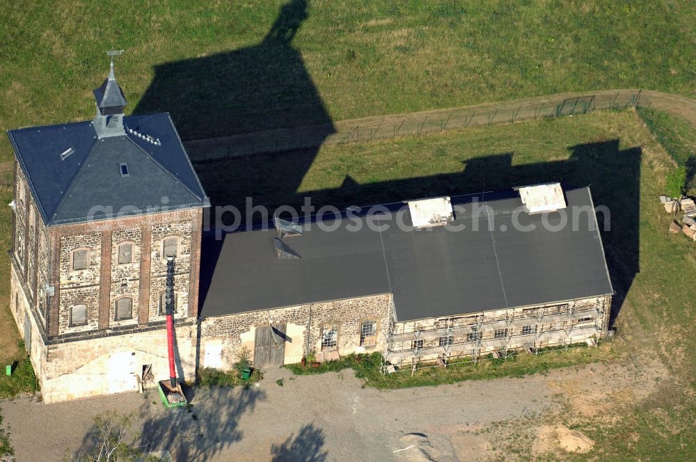 Aerial image Bannewitz - Blick auf den Marienschacht. Der Marienschacht ist ein ehemaliges Steinkohlebergwerk in der Gemeinde Bannewitz. Er bildet ein bergbauhistorisches Ensemble. Die Freiherrlich von Burgker Steinkohlewerke teuften den Schacht zwischen 1886 und 1893 ab, wobei man in etwa 545 m Teufe auf das Hauptsteinkohleflöz von ca. 6 m Mächtigkeit traf. 1930 wurde der Betrieb eingestellt. In der DDR wurde die Steinkohlenförderung wieder aufgenommen, diesmal als Schacht des VEB Steinkohlenwerks „Willi Agatz“. Da die Kohlen einen Urangehalt von ca. 0,3% aufwiesen, übernahm 1968 die SDAG Wismut die Kohlenförderung, um daraus Uran zu gewinnen. 1989 wurde der Schacht endgültig stillgelegt, zurückgebaut und mit Halde bis 1999 durch die Wismut GmbH saniert.Der markante, 1891 errichtete Förderturm, heute ein technisches Denkmal, ist ein im deutschen Raum eher seltener so genannter Malakow-Turm und der zuletzt errichtete seiner Bauart in Deutschland. In den 1960er Jahren wurde eine Kaue angebaut.