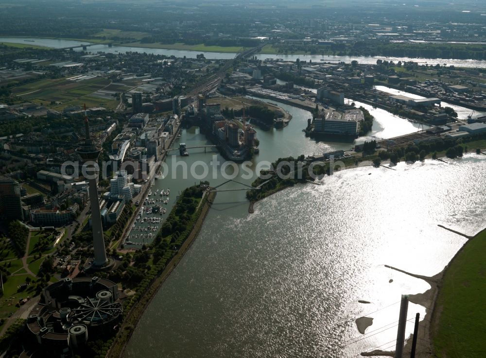 Aerial image Düsseldorf - The harbour Medienhafen and the Rhine Tower in Düsseldorf in the state of North Rhine-Westphalia. The actual harbour is an important industrial and inland port. It was partly rebuilt in the 1990s and therefore made the new Medienhafen area. Here are various media and advertising companies, as well as designers and fashion business located. There are also clubs and bars