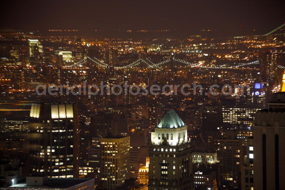 New York from above - Night aerial photo of the city district Lower East Side of Manhattan in New York. Illuminated in the background are the Manhattan Bridge and the Brooklyn Bridge