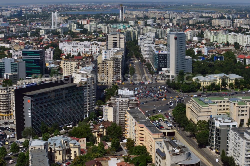 Aerial image Bukarest - The Square Piata Victoriei, the Victory Square, in Sector 1 in Bucharest in Romania. View from the Boulevard Iancu de Hunedoara to the West and the large square and traffic junction, where several large roads of the capital meet and intersect. The square itself consists of several parking lots. An underpass leads the traffic and the street car under the central square. On the Victory square, there are several significant buildings such as the Museum of Natural History Antipa which is surrounded by forest, the Bucharest Tower Center and the BRD Tower, which are the highest buildings of the country. The building with the green roof on the East corner of the square is the Victoria Palace, the government seat of Romania which was built during World War II