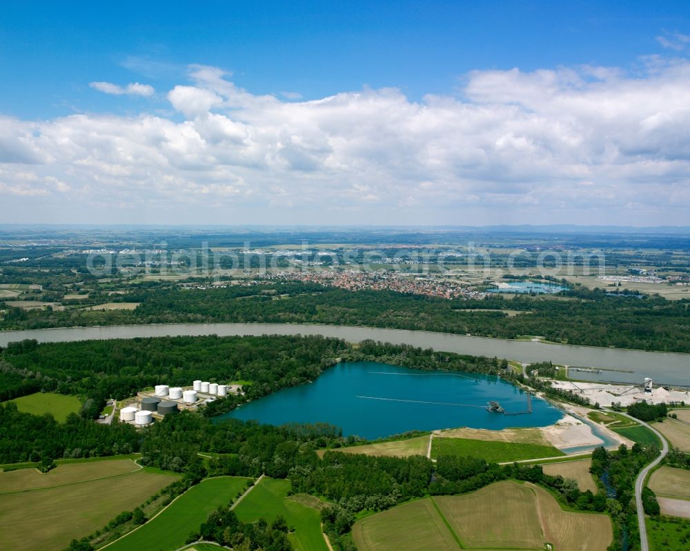 Kehl from the bird's eye view: The river Rhine at the city of Kehl in the state of Baden-Württemberg. In the overview visible is the run of the river through the landscape. The Rhine is the border to France in that area and is important for shipping and transportation and is surrounded by woods, small lakes and fields. The focus lies on the artificial pond Rheinau-Honau