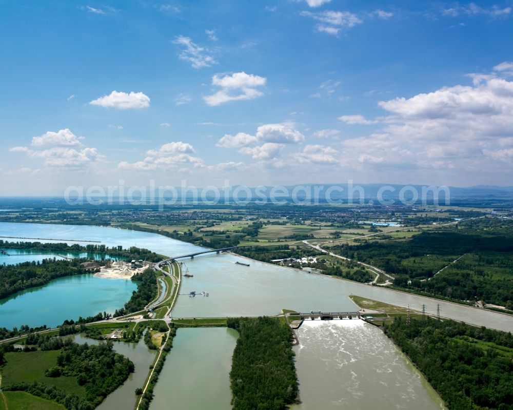 Aerial photograph Kehl - The river Rhine at the city of Kehl in the state of Baden-Württemberg. In the overview visible is the run of the river through the landscape. The Rhine is the border to France in that area and is important for shipping and transportation and is surrounded by woods, small lakes and fields. The focus lies on the artificial pond Rheinau-Honau