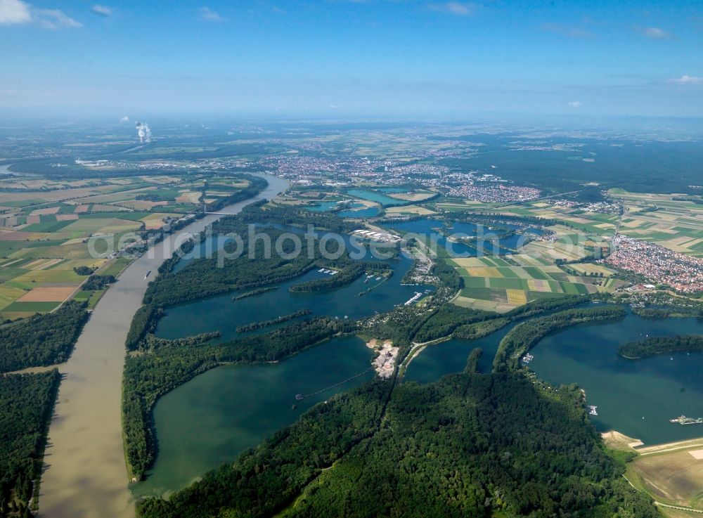 Aerial photograph Mannheim - The river Rhine at the city of Mannheim in the state of Baden-Württemberg. In the overview visible is the run of the river through the landscape. In the background lies Mannheim. The Rhine is important for shipping and transportation and is surrounded by woods, small lakes and fields