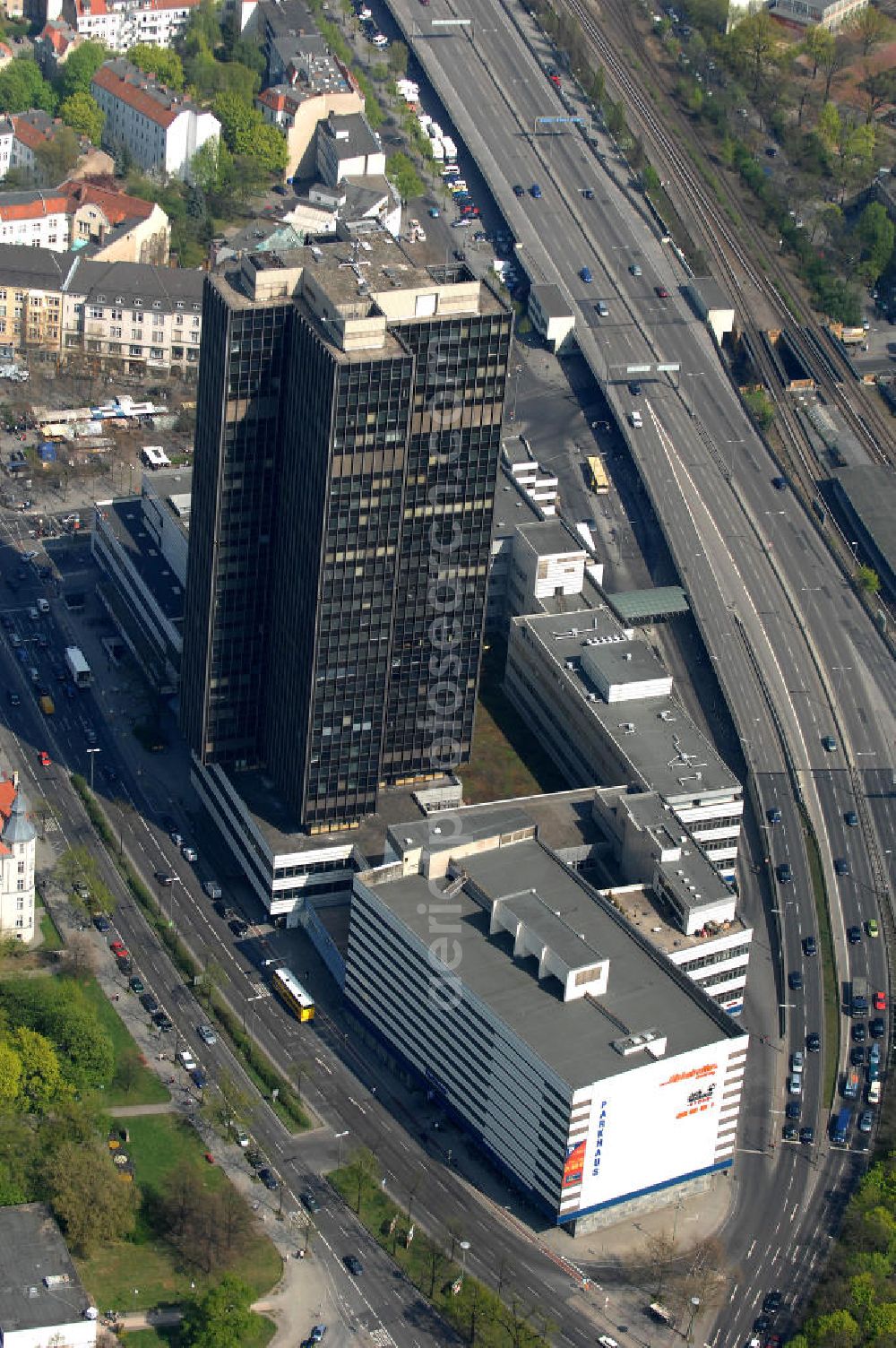 Aerial image Berlin - Blick auf den Steglitzer Kreisel, einem leerstehenden Gebäudekomplex im Berliner Ortsteil Steglitz. Der Steglitzer Kreisel ist ein Gebäudekomplex mit Bürohochhaus im Berliner Ortsteil Steglitz gegenüber dem Rathaus Steglitz gelegen. Den Hauptteil des Gebäudes bildet ein 119 Meter hohes Verwaltungshochhaus mit 27 Stockwerken. Am 27. Juni 2006 hatte der Berliner Senat beschlossen, das Bürohochhaus aufzugeben und die dort beschäftigten Mitarbeiter des Bezirksamts Steglitz-Zehlendorf in an deren landeseigenen Immobilien unterzubringen. Zum 23. November 2007 wurde das Haus geräumt und steht derzeit leer. Die zwei Jahre dauernden Sanierungsarbeiten beginnen frühestens 2009, nachdem die Berliner Finanzverwaltung und der Liegenschaftsfonds nochmals vergeblich versucht hatten, das Gebäude im jetzigen Zustand zu verkaufen. Die weitere Nutzung ist ungeklärt, neben dem Verkauf an Wolfgang Gerbere Investoren wird auch ein Abriss nicht ausgeschlossen, der jedoch in der Öffentlichkeit umstritten ist.