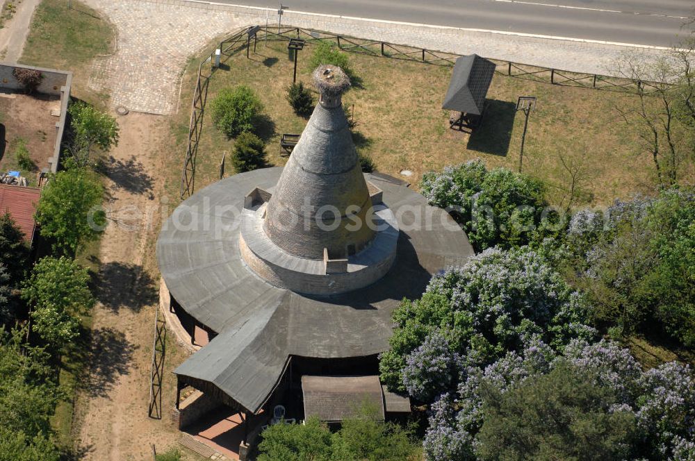 Aerial photograph Rathsdorf - Blick auf den Storchenturm. Ursprünglich war das Gebäude ein Ziegelbrennofen aus dem 19. Jahrhundert. Nach der Stilllegung vor ca. 100 Jahren bauten Störche ihr Nest auf dem Schornstein. Der Turm ist eines der Wahrzeichen des nördlichen Oderbruchs. Seit 1978 befindet sich im Inneren des Turmes ein Storchenmuseum, das von Kurt Kretschmann begründet wurde. In den 90er Jahren wurde das Gebäude umfassend saniert. Betrieben wird es seit 2003 von der NABU auf ehrenamtlicher Basis. Kontakt: NABU Charitéstraße 3, 10117 Berlin, Tel. 030.284 984 - 0, NABU@NABU.de