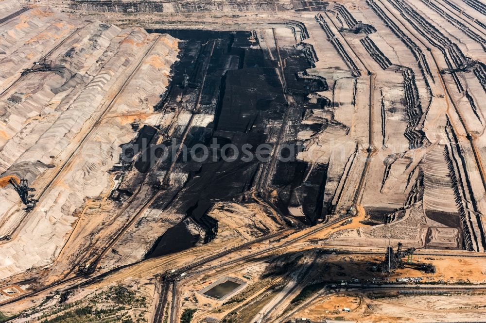 Elsdorf from the bird's eye view: The opencast pit Hambach in Elsdorf in the Rhine area of North Rhine-Westphalia. The area is run by RWE Power AG: It is primarily used for excavating brown and soft coal. The area includes the county district Niederzier, Kreis Dueren and Elsdorf. The pit and mine is often reason for the relocation of villages. Parts of the largest wooded area of the state were destroyed and old settlements such as Manheim or Etzweiler had to be relocated