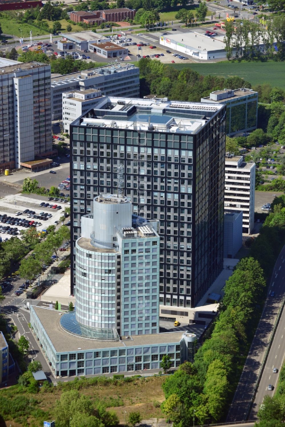 Eschborn from the bird's eye view: The Taunus Tower in Eschborn in the metropolitan area of Frankfurt in the state of Hessen. The office complex lies in the commercial area South. In the back lies one of the locations and facilities of the Group Deutsche Börse, which is also home of the Art Collection Deutsche Börse