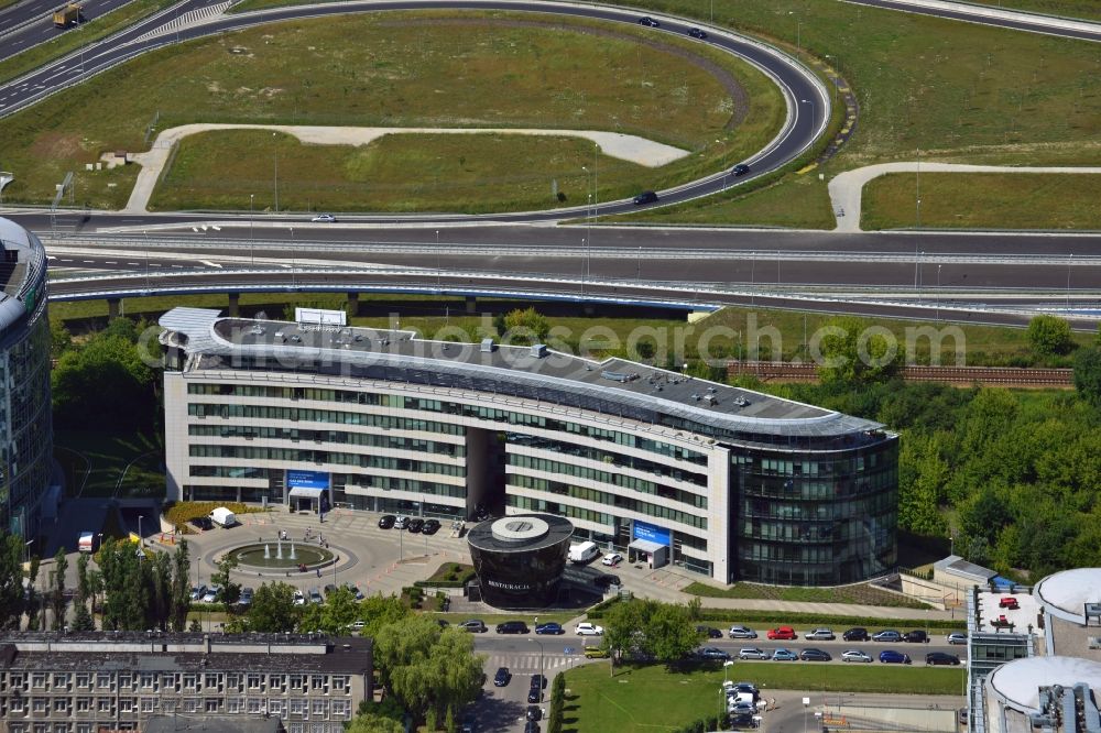 Warschau from the bird's eye view: The Trinity Park II office buildings in Sluzewiec in the Mokotow district of Warsaw in Poland. The complex consists of the round South building and the semicircular lower North building. It is run by DTZ and Emporis. The Southern building is home to offices of the PNB Paribas Bank. The compound is directly adjacent to the traffic junction of the S79 Expressway, which was completed in 2013 and is a spur route connecting inner-city roads