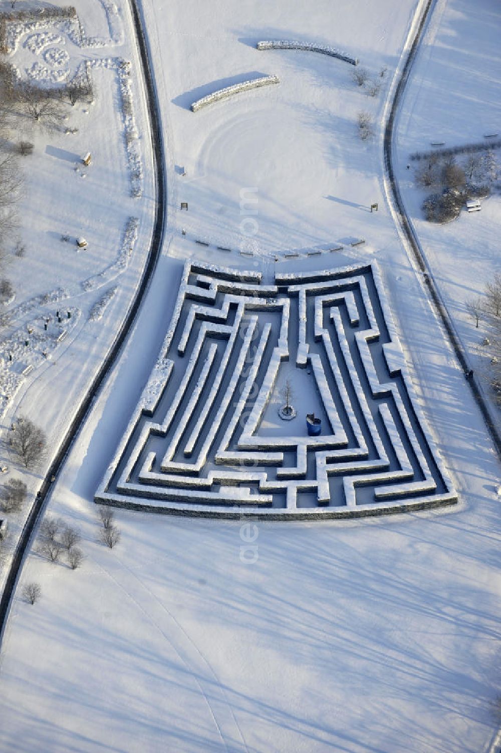 Aerial photograph Berlin - Blick auf den Irrgarten im Erholungspark Marzahn. Das winterlich verschneite Labyrinth im Erholungspark Marzahn liegt im Berliner Bezirk Marzahn-Hellersdorf am nördlichen Fuß des Kienbergs. 2005 wurde der Chinesische Garten im Erholungspark Marzahn als drittschönste Parkanlage Deutschlands ausgezeichnet. Wintry Labyrinth area of the Marzahn Recreational Park.