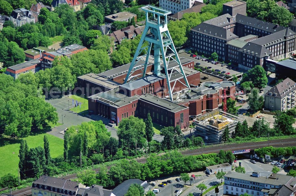 Aerial photograph BOCHUM - Das Deutsche Bergbau-Museum Bochum (DBM) ist mit seinen rund 400.000 Besuchern pro Jahr eines der meist besuchten Museen Deutschlands. Es ist eines der bedeutendsten Bergbaumuseen der Welt und zugleich ein renommiertes Forschungsinstitut für Montangeschichte.Übertägige Ausstellungen und ein originalgetreues Anschauungsbergwerk unterhalb des Museumsgeländes eröffnen den Besuchern Einblicke in die Welt des Bergbaus. Forschungsschwerpunkte der Wissenschaftler sind die „Geschichte und Technik des Montanwesens“ sowie „Dokumentation und Schutz von Kulturgut“. Das Museum ist als Forschungseinrichtung Mitglied der Leibniz-Gemeinschaft.Die Anfänge des Bergbau-Museums gehen zurück auf die 1860er Jahre, als die Westfälische Berggewerkschaftskasse (WBK) eine ständige Ausstellung „Bergbaulicher Utensilien“ in Bochum einrichtet, die hauptsächlich dem Bergschulunterricht diente. Ende der 1920er Jahre wurden von Vertretern der WBK und der Stadt Bochum Überlegungen zur Gründung eines öffentlich zugänglichen „Bergbau-Museums“ entwickelt.