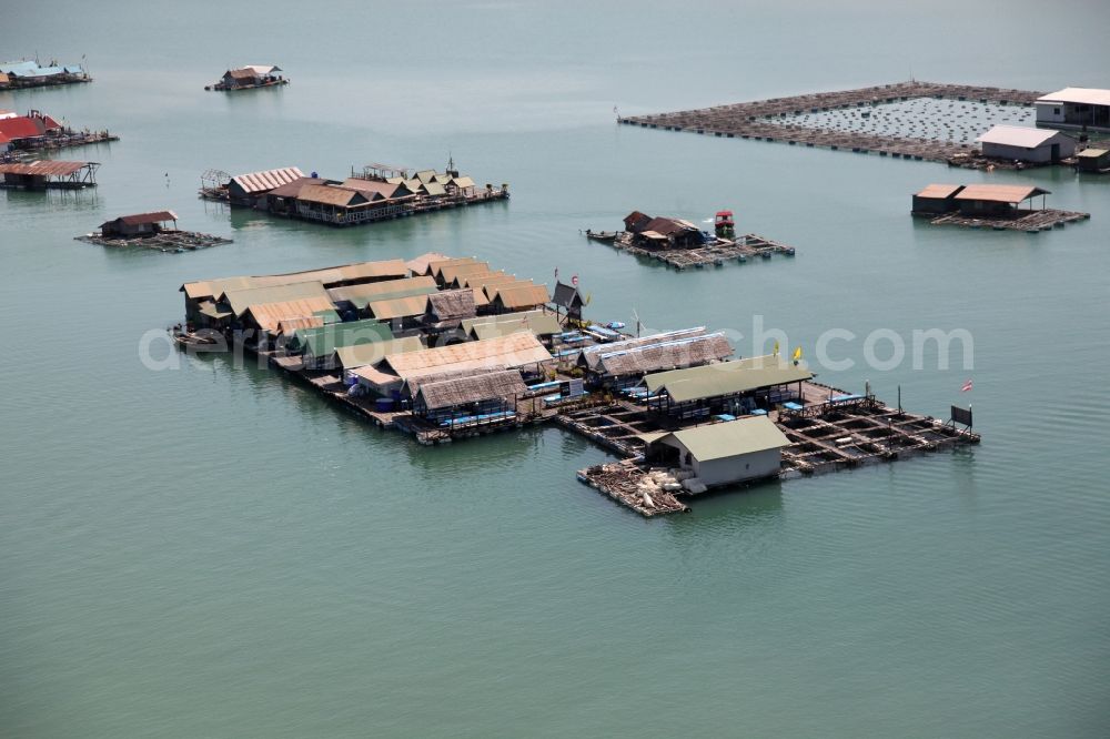 Ratsada from above - The Bay Ao Tha Rua in front of the city Ratsada on the island Phuket in Thailand is full of floating fish farms with accompanying boats and houseboats