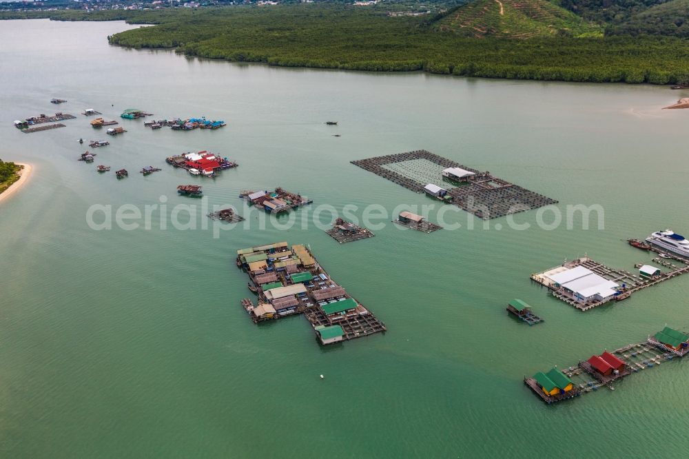 Tambon Ko Kaeo from above - The Bay Ao Tha Rua in front of the city Ratsada on the island Phuket in Thailand is full of floating fish farms with accompanying boats and houseboats