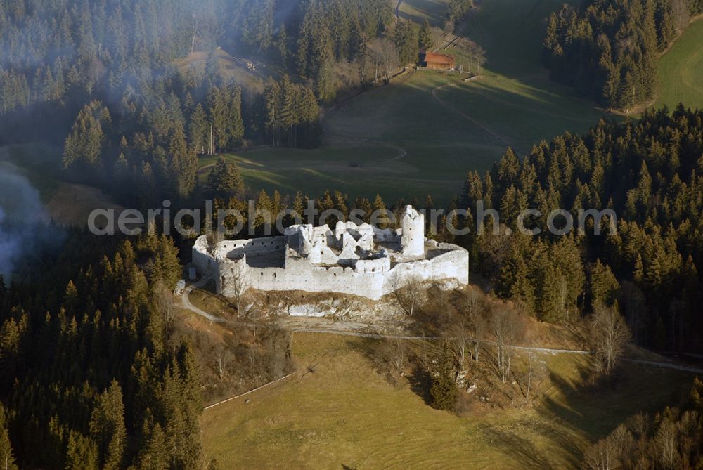 Eisenberg from the bird's eye view: Die Burg Hohenfreyberg bildet zusammen mit der direkt gegenüber liegenden Burg Eisenberg eine weithin sichtbare Burgengruppe im südlichen Allgäu.Die Burg gilt als einer der letzten großen Burgneubauten des deutschen Mittelalters. 1646, gegen Ende des Dreißigjährigen Krieges, wurden die österreichischen Vorposten Hohenfreyberg, Eisenberg und Falkenstein auf Befehl der Tiroler Landesregierung in Brand gesetzt. Die Burganlagen sollten den näherrückenden Protestanten nicht intakt in die Hände fallen. Allerdings änderten die Angreifer ihre Marschroute, die Aufgabe der Burgen war also sinnlos. Alle drei Anlagen sind seitdem unbewohnte Ruinen.Nach der Schlacht bei Austerlitz musste Österreich seine Allgäuer Besitzungen an Bayern abtreten. Das Königreich Bayern veräußerte Hohenfreyberg 1841 wieder zurück an die Freiherren von Freyberg, denen die Burg noch heute gehört.