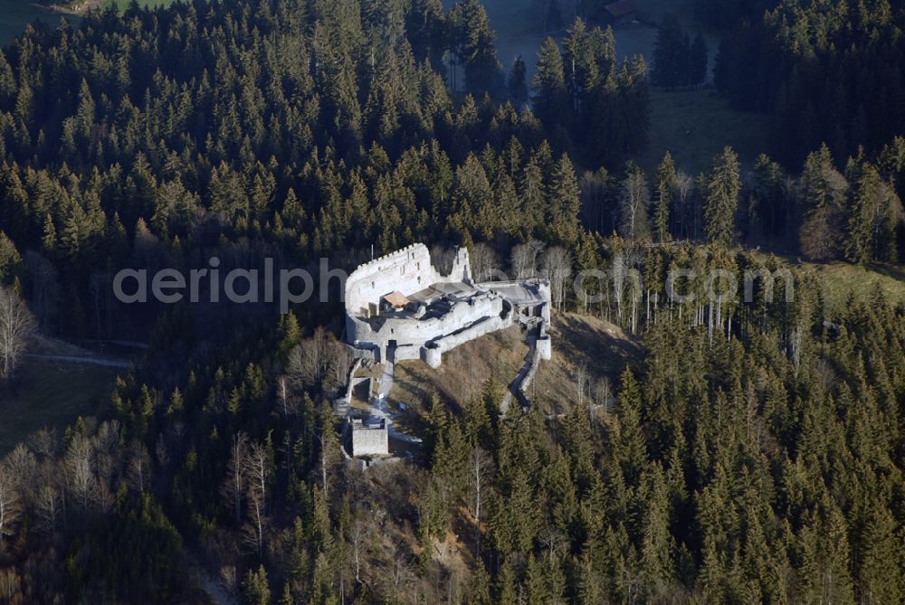 Aerial image Eisenberg - Die Burg Hohenfreyberg bildet zusammen mit der direkt gegenüber liegenden Burg Eisenberg eine weithin sichtbare Burgengruppe im südlichen Allgäu.Die Burg gilt als einer der letzten großen Burgneubauten des deutschen Mittelalters. 1646, gegen Ende des Dreißigjährigen Krieges, wurden die österreichischen Vorposten Hohenfreyberg, Eisenberg und Falkenstein auf Befehl der Tiroler Landesregierung in Brand gesetzt. Die Burganlagen sollten den näherrückenden Protestanten nicht intakt in die Hände fallen. Allerdings änderten die Angreifer ihre Marschroute, die Aufgabe der Burgen war also sinnlos. Alle drei Anlagen sind seitdem unbewohnte Ruinen.Nach der Schlacht bei Austerlitz musste Österreich seine Allgäuer Besitzungen an Bayern abtreten. Das Königreich Bayern veräußerte Hohenfreyberg 1841 wieder zurück an die Freiherren von Freyberg, denen die Burg noch heute gehört.