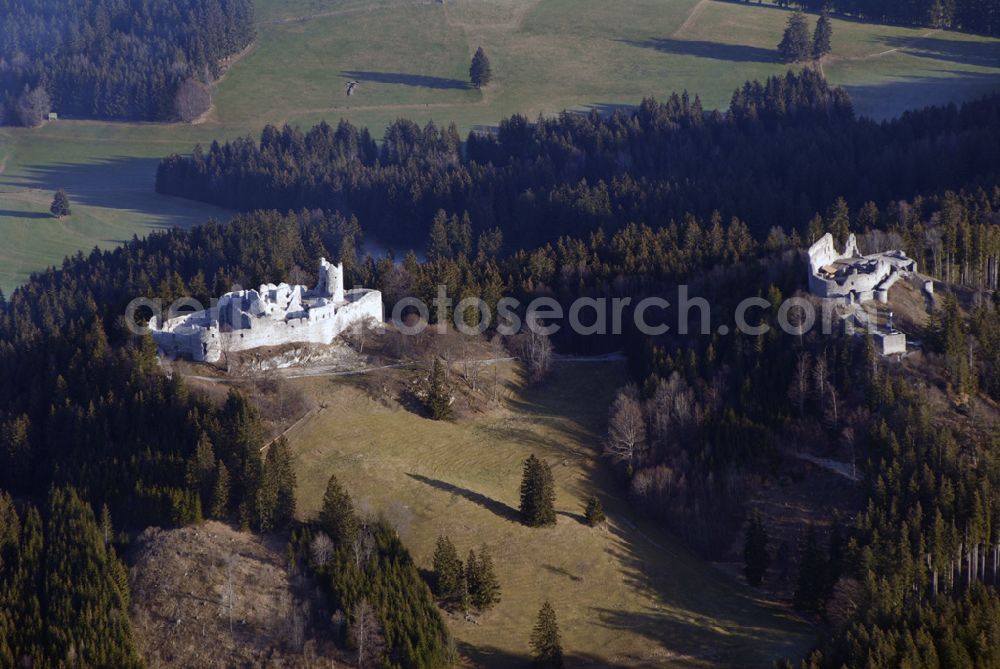 Aerial photograph Eisenberg - Die Burg Hohenfreyberg bildet zusammen mit der direkt gegenüber liegenden Burg Eisenberg eine weithin sichtbare Burgengruppe im südlichen Allgäu.Die Burg gilt als einer der letzten großen Burgneubauten des deutschen Mittelalters. 1646, gegen Ende des Dreißigjährigen Krieges, wurden die österreichischen Vorposten Hohenfreyberg, Eisenberg und Falkenstein auf Befehl der Tiroler Landesregierung in Brand gesetzt. Die Burganlagen sollten den näherrückenden Protestanten nicht intakt in die Hände fallen. Allerdings änderten die Angreifer ihre Marschroute, die Aufgabe der Burgen war also sinnlos. Alle drei Anlagen sind seitdem unbewohnte Ruinen.Nach der Schlacht bei Austerlitz musste Österreich seine Allgäuer Besitzungen an Bayern abtreten. Das Königreich Bayern veräußerte Hohenfreyberg 1841 wieder zurück an die Freiherren von Freyberg, denen die Burg noch heute gehört.