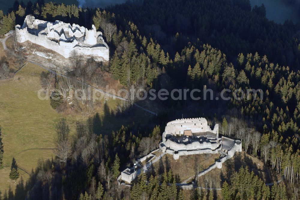 Eisenberg from the bird's eye view: Die Burg Hohenfreyberg bildet zusammen mit der direkt gegenüber liegenden Burg Eisenberg eine weithin sichtbare Burgengruppe im südlichen Allgäu.Die Burg gilt als einer der letzten großen Burgneubauten des deutschen Mittelalters. 1646, gegen Ende des Dreißigjährigen Krieges, wurden die österreichischen Vorposten Hohenfreyberg, Eisenberg und Falkenstein auf Befehl der Tiroler Landesregierung in Brand gesetzt. Die Burganlagen sollten den näherrückenden Protestanten nicht intakt in die Hände fallen. Allerdings änderten die Angreifer ihre Marschroute, die Aufgabe der Burgen war also sinnlos. Alle drei Anlagen sind seitdem unbewohnte Ruinen.Nach der Schlacht bei Austerlitz musste Österreich seine Allgäuer Besitzungen an Bayern abtreten. Das Königreich Bayern veräußerte Hohenfreyberg 1841 wieder zurück an die Freiherren von Freyberg, denen die Burg noch heute gehört.