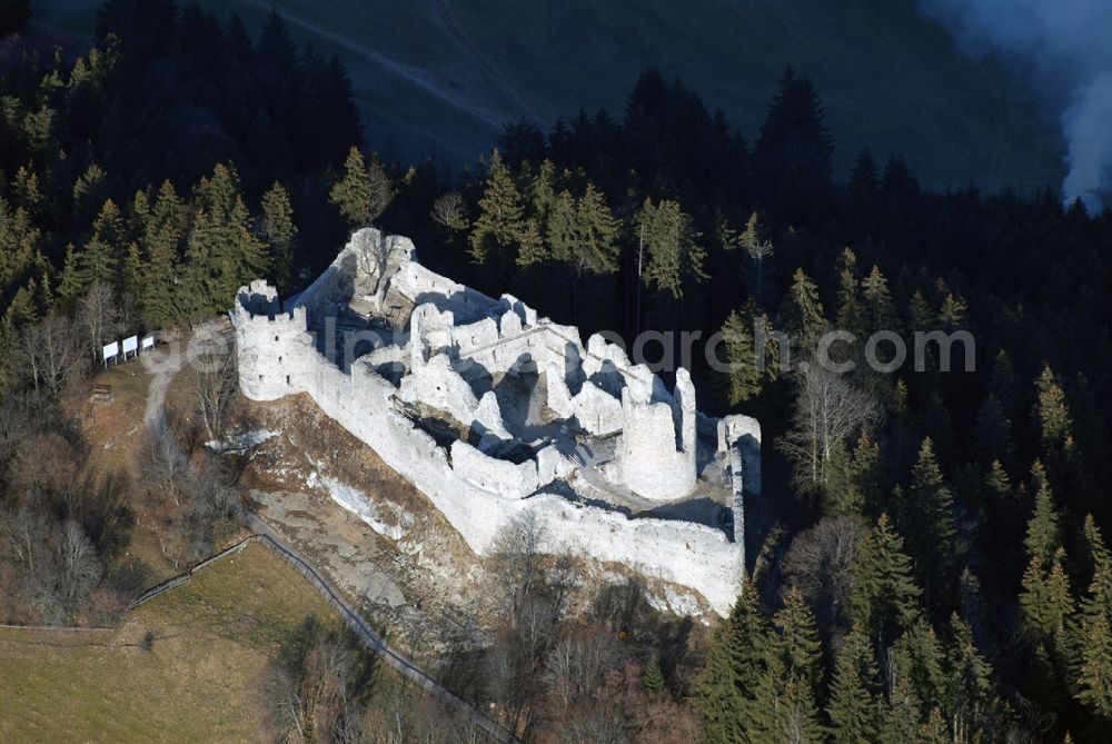 Aerial photograph Eisenberg - Die Burg Hohenfreyberg bildet zusammen mit der direkt gegenüber liegenden Burg Eisenberg eine weithin sichtbare Burgengruppe im südlichen Allgäu.Die Burg gilt als einer der letzten großen Burgneubauten des deutschen Mittelalters. 1646, gegen Ende des Dreißigjährigen Krieges, wurden die österreichischen Vorposten Hohenfreyberg, Eisenberg und Falkenstein auf Befehl der Tiroler Landesregierung in Brand gesetzt. Die Burganlagen sollten den näherrückenden Protestanten nicht intakt in die Hände fallen. Allerdings änderten die Angreifer ihre Marschroute, die Aufgabe der Burgen war also sinnlos. Alle drei Anlagen sind seitdem unbewohnte Ruinen.Nach der Schlacht bei Austerlitz musste Österreich seine Allgäuer Besitzungen an Bayern abtreten. Das Königreich Bayern veräußerte Hohenfreyberg 1841 wieder zurück an die Freiherren von Freyberg, denen die Burg noch heute gehört.