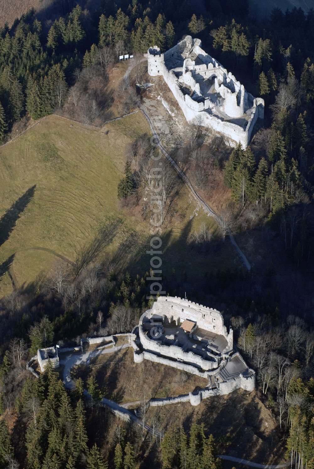 Eisenberg from the bird's eye view: Die Burg Hohenfreyberg bildet zusammen mit der direkt gegenüber liegenden Burg Eisenberg eine weithin sichtbare Burgengruppe im südlichen Allgäu.Die Burg gilt als einer der letzten großen Burgneubauten des deutschen Mittelalters. 1646, gegen Ende des Dreißigjährigen Krieges, wurden die österreichischen Vorposten Hohenfreyberg, Eisenberg und Falkenstein auf Befehl der Tiroler Landesregierung in Brand gesetzt. Die Burganlagen sollten den näherrückenden Protestanten nicht intakt in die Hände fallen. Allerdings änderten die Angreifer ihre Marschroute, die Aufgabe der Burgen war also sinnlos. Alle drei Anlagen sind seitdem unbewohnte Ruinen.Nach der Schlacht bei Austerlitz musste Österreich seine Allgäuer Besitzungen an Bayern abtreten. Das Königreich Bayern veräußerte Hohenfreyberg 1841 wieder zurück an die Freiherren von Freyberg, denen die Burg noch heute gehört.