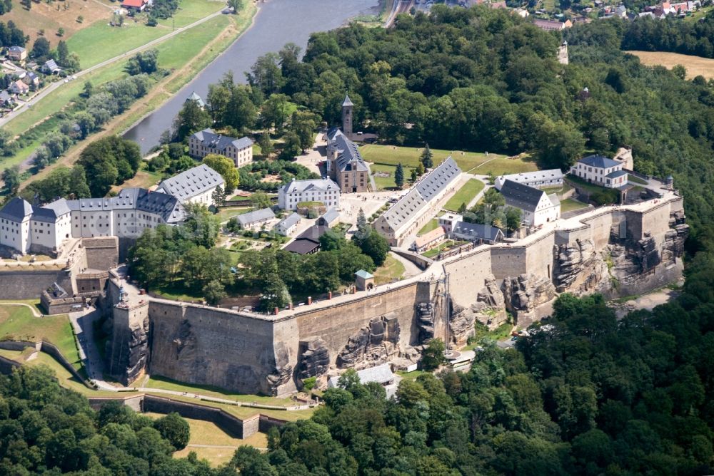 Aerial image Königstein - The Fortress Koenigstein at the river Elbe in the county district of Saxon Switzerland East Erzgebirge in the state of Saxony. The fortress is one of the largest mountain fortresses in Europe and is located amidst the Elbe sand stone mountains on the flat top mountain of the same name. In front of it, the river runs through a valley