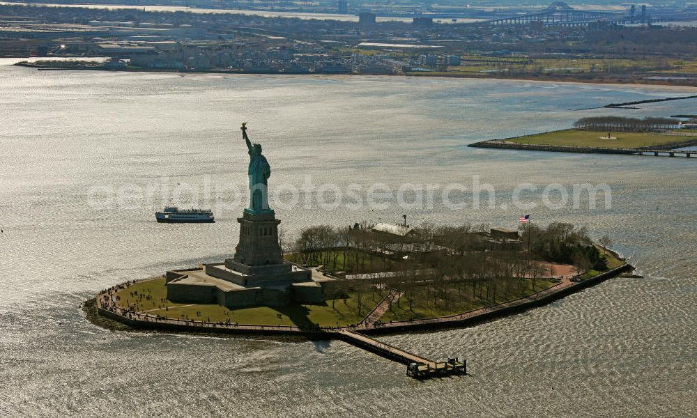 Aerial image New York - Die Freiheitsstatue ist eine von Frédéric-Auguste Bartholdi geschaffene neoklassizistische Kolossalstatue bei New York. Sie steht auf Liberty Island im New Yorker Hafen und wurde am 28. Oktober 1886 eingeweiht. Die Statue ist seit 1984 als Weltkulturerbe der UNESCO klassifiziert. Die Statue stellt die in Roben gehüllte Figur der Libertas, der römischen Göttin der Freiheit, dar. / The Statue of Liberty is a statue created by Frédéric-Auguste Bartholdi. It stands on Liberty Iceland in the New York harbor, and was inaugurated in October 1886. The statue has been classified since 1984 as a World Heritage Site by UNESCO. The statue represents the figure of Libertas, the Roman goddess of freedom.