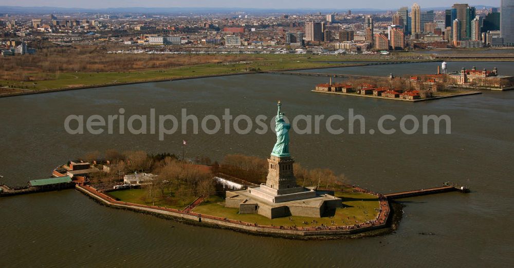 New York from the bird's eye view: Die Freiheitsstatue ist eine von Frédéric-Auguste Bartholdi geschaffene neoklassizistische Kolossalstatue bei New York. Sie steht auf Liberty Island im New Yorker Hafen und wurde am 28. Oktober 1886 eingeweiht. Die Statue ist seit 1984 als Weltkulturerbe der UNESCO klassifiziert. Die Statue stellt die in Roben gehüllte Figur der Libertas, der römischen Göttin der Freiheit, dar. / The Statue of Liberty is a statue created by Frédéric-Auguste Bartholdi. It stands on Liberty Iceland in the New York harbor, and was inaugurated in October 1886. The statue has been classified since 1984 as a World Heritage Site by UNESCO. The statue represents the figure of Libertas, the Roman goddess of freedom.