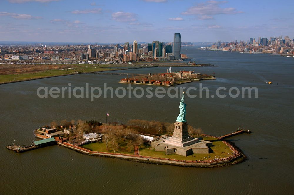 Aerial image New York - Die Freiheitsstatue ist eine von Frédéric-Auguste Bartholdi geschaffene neoklassizistische Kolossalstatue bei New York. Sie steht auf Liberty Island im New Yorker Hafen und wurde am 28. Oktober 1886 eingeweiht. Die Statue ist seit 1984 als Weltkulturerbe der UNESCO klassifiziert. Die Statue stellt die in Roben gehüllte Figur der Libertas, der römischen Göttin der Freiheit, dar. / The Statue of Liberty is a statue created by Frédéric-Auguste Bartholdi. It stands on Liberty Iceland in the New York harbor, and was inaugurated in October 1886. The statue has been classified since 1984 as a World Heritage Site by UNESCO. The statue represents the figure of Libertas, the Roman goddess of freedom.