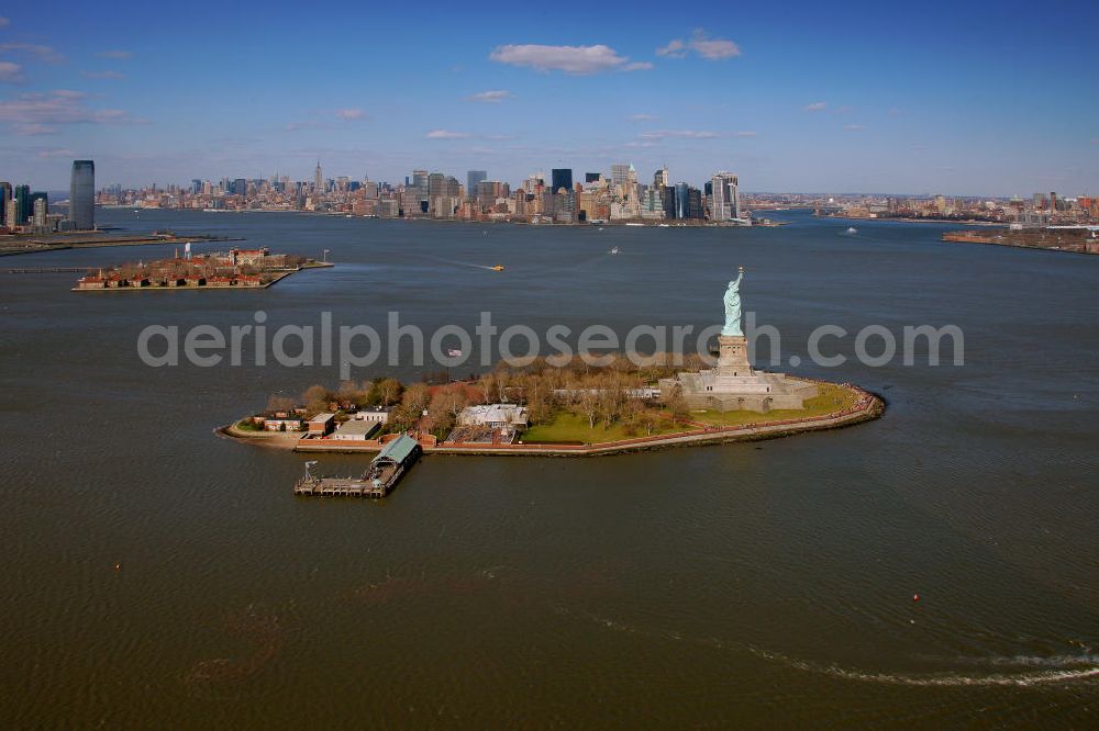 New York from above - Die Freiheitsstatue ist eine von Frédéric-Auguste Bartholdi geschaffene neoklassizistische Kolossalstatue bei New York. Sie steht auf Liberty Island im New Yorker Hafen und wurde am 28. Oktober 1886 eingeweiht. Die Statue ist seit 1984 als Weltkulturerbe der UNESCO klassifiziert. Die Statue stellt die in Roben gehüllte Figur der Libertas, der römischen Göttin der Freiheit, dar. / The Statue of Liberty is a statue created by Frédéric-Auguste Bartholdi. It stands on Liberty Iceland in the New York harbor, and was inaugurated in October 1886. The statue has been classified since 1984 as a World Heritage Site by UNESCO. The statue represents the figure of Libertas, the Roman goddess of freedom.