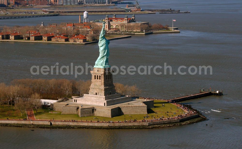 Aerial image New York - Die Freiheitsstatue ist eine von Frédéric-Auguste Bartholdi geschaffene neoklassizistische Kolossalstatue bei New York. Sie steht auf Liberty Island im New Yorker Hafen und wurde am 28. Oktober 1886 eingeweiht. Die Statue ist seit 1984 als Weltkulturerbe der UNESCO klassifiziert. Die Statue stellt die in Roben gehüllte Figur der Libertas, der römischen Göttin der Freiheit, dar. / The Statue of Liberty is a statue created by Frédéric-Auguste Bartholdi. It stands on Liberty Iceland in the New York harbor, and was inaugurated in October 1886. The statue has been classified since 1984 as a World Heritage Site by UNESCO. The statue represents the figure of Libertas, the Roman goddess of freedom.