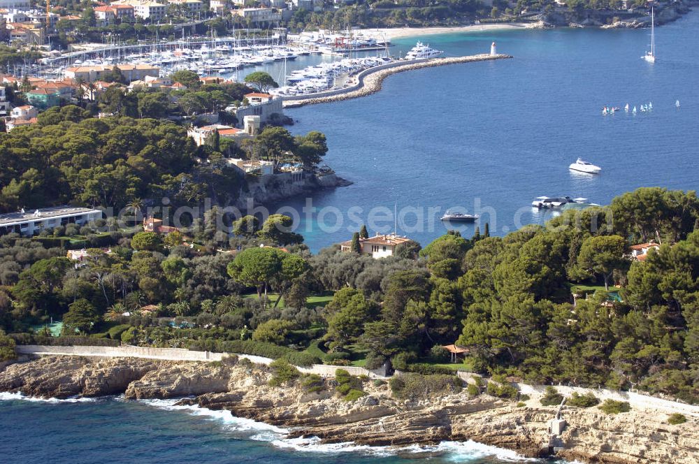 Aerial photograph Saint-Jean-Cap-Ferrat - Blick auf die Halbinsel Saint-Jean-Cap-Ferrat und den Hafen. Das Cap Ferrat ist eine Halbinsel an der Cote d'Azur. Sie liegt zwischen Nizza und Monaco. Es trennt Beaulieu-sur-Mer und Villefranche-sur-Mer. Der Ort Saint-Jean-Cap-Ferrat erstreckt sich an seinem Ostufer. Die ganze Halbinsel kann auf einem Fußweg umrundet werden. An ihrer Spitze steht ein Leuchtturm als Hafenwegweiser.