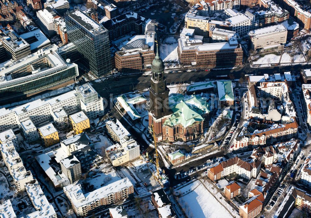 Hamburg from the bird's eye view: Die winterlich verschneite evangelische Hauptkirche Sankt Michaelis, genannt „Michel“, ist die bekannteste Kirche Hamburgs und ein Wahrzeichen der Hansestadt, da sie für Seeleute auf einlaufenden Schiffen gut sichtbar ist. Sie gilt als bedeutendste Barockkirche Norddeutschlands und ist dem Erzengel Michael geweiht, der als große Bronzestatue über dem Hauptportal steht. Der Michel steht in der südlichen Neustadt zwischen Ludwig-Erhard-Straße, Krayenkamp und Englischer Planke. The main Protestant church of St. Michaelis, called Michel is the most famous church in Hamburg and a emblem of the Hanseatic city, because for the seamen it is easy to see.