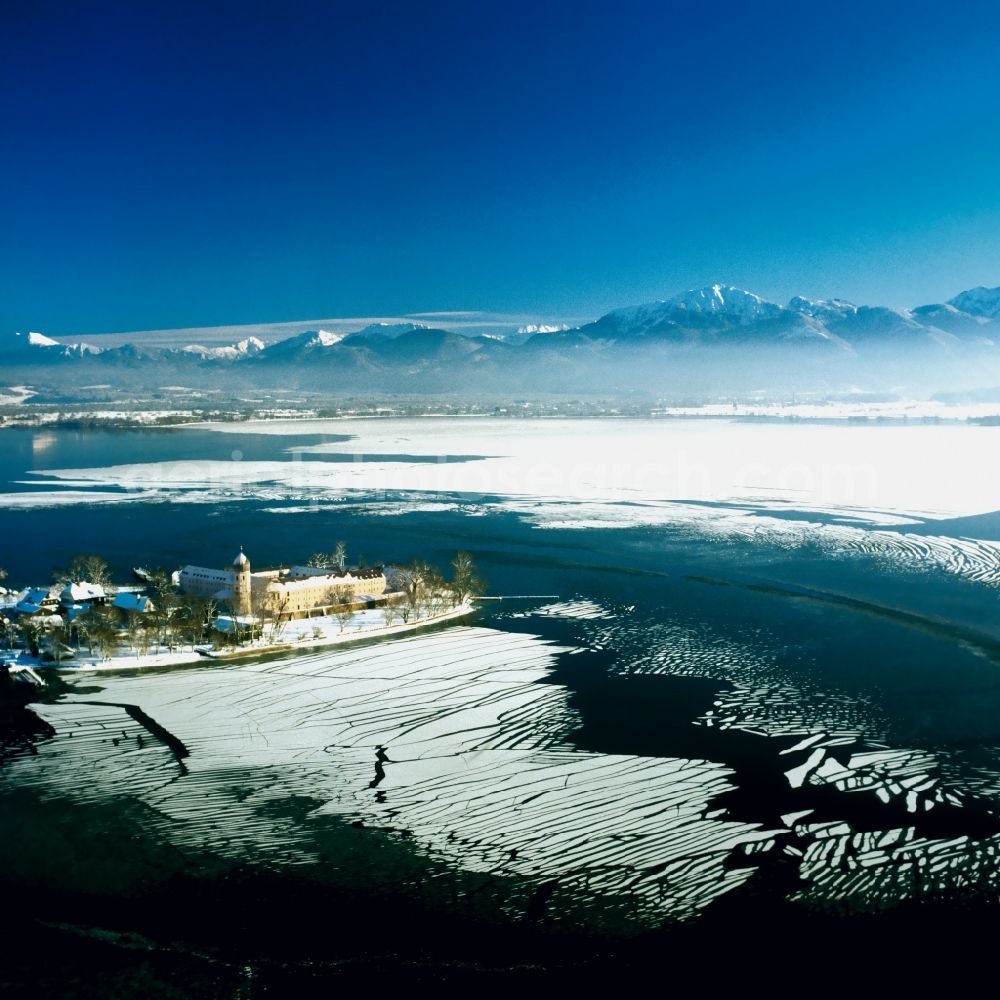 Aerial photograph Frauenchiemsee - The island Frauenchiemsee in the lake Chiemsee in the state of Bavaria. The island is car free and reachable via ship throughout the year. The island is snow covered and the lake is frozen