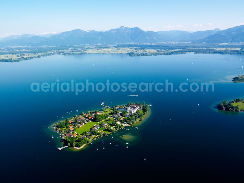 Aerial photograph Chiemsee - The island Frauenchiemsee in Lake Chiemsee in the state of Bavaria. The Chiemsee, also called the Bavarian Sea, is the third largest lake in Germany. The region around the lake, the Chiemgau, is one of the most favoured recreational areas of Bavaria. The lake itself is a renowned watersports and leisure area. View from the village of Gstadt south towards the Alps. The island is car-free