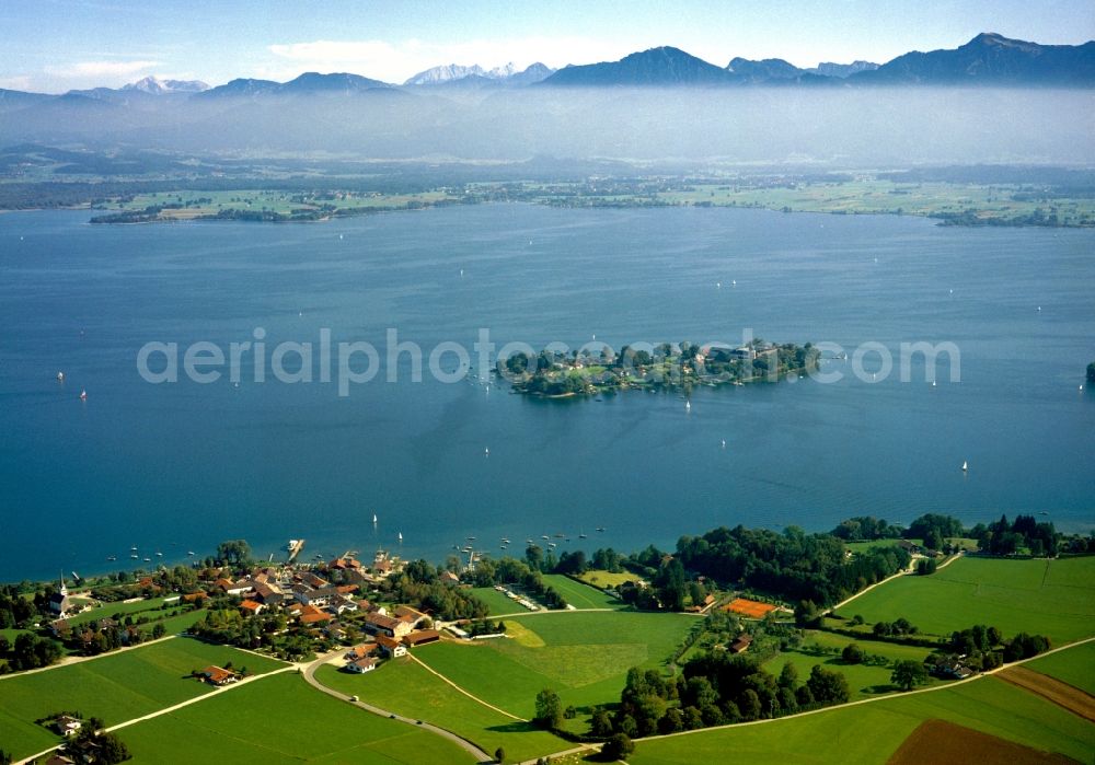 Aerial photograph Chiemsee - The island Frauenchiemsee in Lake Chiemsee in the state of Bavaria. The Chiemsee, also called the Bavarian Sea, is the third largest lake in Germany. The region around the lake, the Chiemgau, is one of the most favoured recreational areas of Bavaria. The lake itself is a renowned watersports and leisure area. View from the village of Gstadt south towards the Alps. The island is car-free