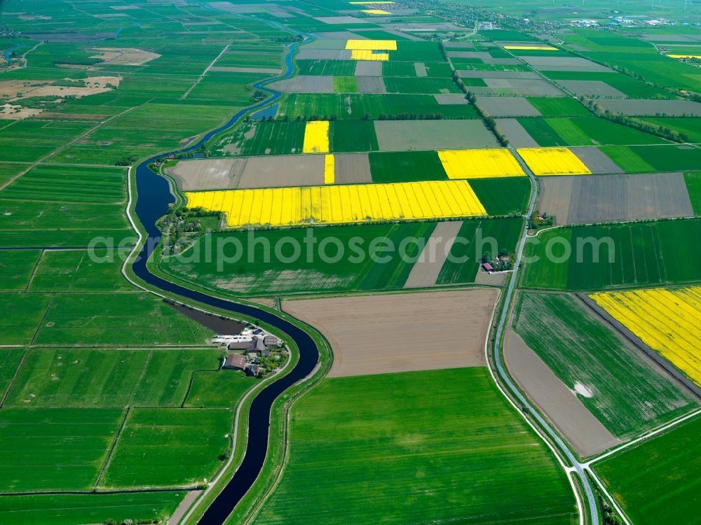 Aerial image Emden - The landscape on the Ems-Jade-Channel in the Uphusen part of the city of Emden in the state of Lower Saxony. The landscape is characterised by the channel, where some settlements and houses are built, and agricultural areas and fields. The channel then runs through the urban area of Emden