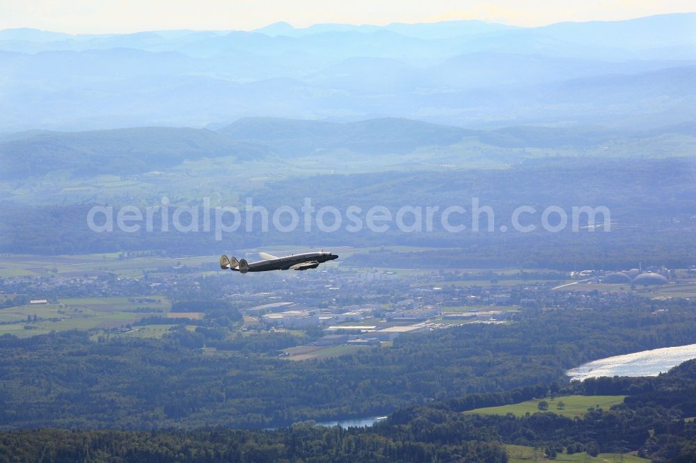 Aerial photograph Rheinfelden (Baden) - The historic airliner Lockheed Super Constellation ( HB - RSC , type L -1049 ) flies over the landscape on the Upper Rhine at Rheinfelden in Baden -Wuerttemberg. The Breitling Super Constellation is stationed at the Euroairport in Basel and is operated by the Super Constellation Flyers Association. It is 60 years old and one of only two airworthy specimens of this type of aircraft in the whole world