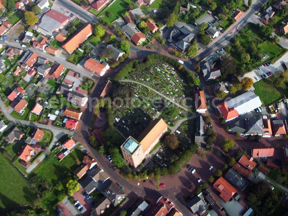 Aerial image Marienhafe - 18.10.2005 Marienhafe; Marienhafe ist eine Gemeinde, zugleich Flecken, und Verwaltungssitz in der Samtgemeinde Brookmerland im Landkreis Aurich in Ostfriesland. Die Gemeinde hatte 2004 etwa 1.900 Einwohner und erstreckt sich auf einer Fläche von 4,06 Quadratkilometern. Marienhafe ist damit eine der kleinsten Gemeinden in Niedersachsen. Marienhafe hat mehrere Sehenswürdigkeiten und Wahrzeichen zu bieten. Das bekannteste ist sicherlich die St. Marienkirche mit dem Störtebekerturm. Die Kirche wurde in der Mitte des 13. Jahrhunderts als dreischiffige, gewölbte Kreuzbasilika erbaut.