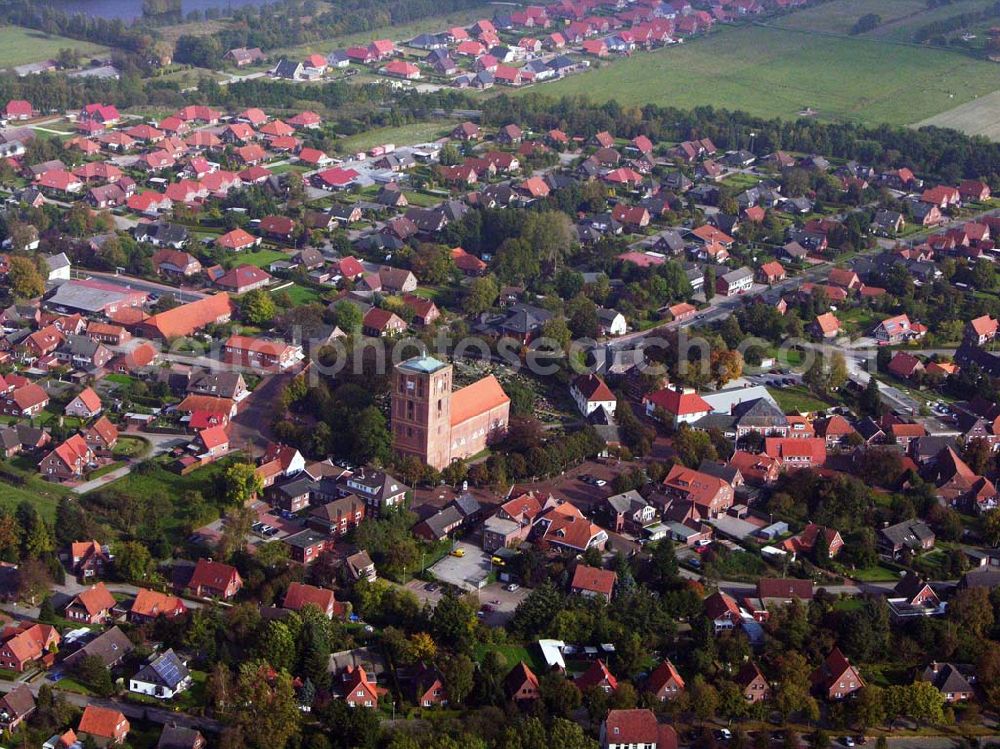 Aerial photograph Marienhafe - 18.10.2005 Marienhafe; Marienhafe ist eine Gemeinde, zugleich Flecken, und Verwaltungssitz in der Samtgemeinde Brookmerland im Landkreis Aurich in Ostfriesland. Die Gemeinde hatte 2004 etwa 1.900 Einwohner und erstreckt sich auf einer Fläche von 4,06 Quadratkilometern. Marienhafe ist damit eine der kleinsten Gemeinden in Niedersachsen. Marienhafe hat mehrere Sehenswürdigkeiten und Wahrzeichen zu bieten. Das bekannteste ist sicherlich die St. Marienkirche mit dem Störtebekerturm. Die Kirche wurde in der Mitte des 13. Jahrhunderts als dreischiffige, gewölbte Kreuzbasilika erbaut.