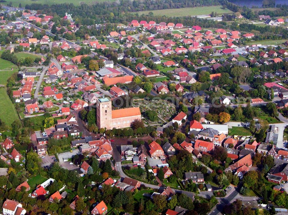 Marienhafe from above - 18.10.2005 Marienhafe; Marienhafe ist eine Gemeinde, zugleich Flecken, und Verwaltungssitz in der Samtgemeinde Brookmerland im Landkreis Aurich in Ostfriesland. Die Gemeinde hatte 2004 etwa 1.900 Einwohner und erstreckt sich auf einer Fläche von 4,06 Quadratkilometern. Marienhafe ist damit eine der kleinsten Gemeinden in Niedersachsen. Marienhafe hat mehrere Sehenswürdigkeiten und Wahrzeichen zu bieten. Das bekannteste ist sicherlich die St. Marienkirche mit dem Störtebekerturm. Die Kirche wurde in der Mitte des 13. Jahrhunderts als dreischiffige, gewölbte Kreuzbasilika erbaut.