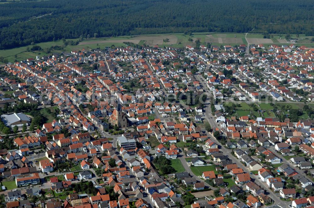 HAMBRÜCKEN from the bird's eye view: Blick auf die Pfarrkirche Hambrücken und das Wohngebiet entlang der Kirchstraße und der Rheinstraße. Hambrücken ist eine Gemeinde im Landkreis Karlsruhe in Baden-Württemberg. Hambrücken liegt in der Oberrheinebene westlich der Bundesautobahn 5, rund 10 km nord-nordwestlich von Bruchsal. Obwohl der Ort in kirchlichem Besitz war, wurde erst 1510 erstmals eine Pfarrkirche erwähnt. Diese Holzkirche wurde von Fürstbischof Damian Hugo von Schönborn durch eine massive Barockkirche mit Zwiebelturm ersetzt, die er 1742 selbst einweihte. Kontakt: Gemeinde Hambrücken, Hauptstr. 108, 76707 Hambrücken, Tel. +49 (0)72 55 71 00 0, Fax +49 (0)72 55 71 00 88, e-mail: gemeinde@hambruecken.de; Kontakt Katholisches Pfarramt: Pfarrer Armin Haas und Klaus Zöllner, Pfarrbüro: Frau Kretzler, Kirchstr. 2, Tel. +49 (0)7255 9410, Fax +49 (0)7255 6931