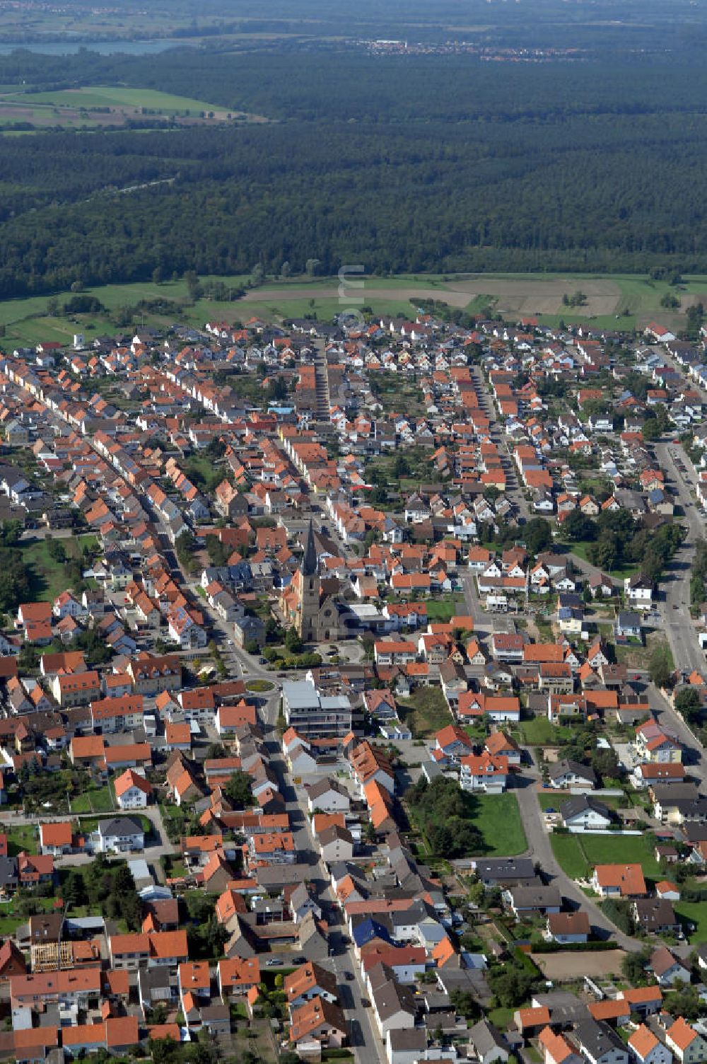 Aerial photograph HAMBRÜCKEN - Blick auf die Pfarrkirche Hambrücken und das Wohngebiet entlang der Kirchstraße und der Rheinstraße. Hambrücken ist eine Gemeinde im Landkreis Karlsruhe in Baden-Württemberg. Hambrücken liegt in der Oberrheinebene westlich der Bundesautobahn 5, rund 10 km nord-nordwestlich von Bruchsal. Obwohl der Ort in kirchlichem Besitz war, wurde erst 1510 erstmals eine Pfarrkirche erwähnt. Diese Holzkirche wurde von Fürstbischof Damian Hugo von Schönborn durch eine massive Barockkirche mit Zwiebelturm ersetzt, die er 1742 selbst einweihte. Kontakt: Gemeinde Hambrücken, Hauptstr. 108, 76707 Hambrücken, Tel. +49 (0)72 55 71 00 0, Fax +49 (0)72 55 71 00 88, e-mail: gemeinde@hambruecken.de; Kontakt Katholisches Pfarramt: Pfarrer Armin Haas und Klaus Zöllner, Pfarrbüro: Frau Kretzler, Kirchstr. 2, Tel. +49 (0)7255 9410, Fax +49 (0)7255 6931