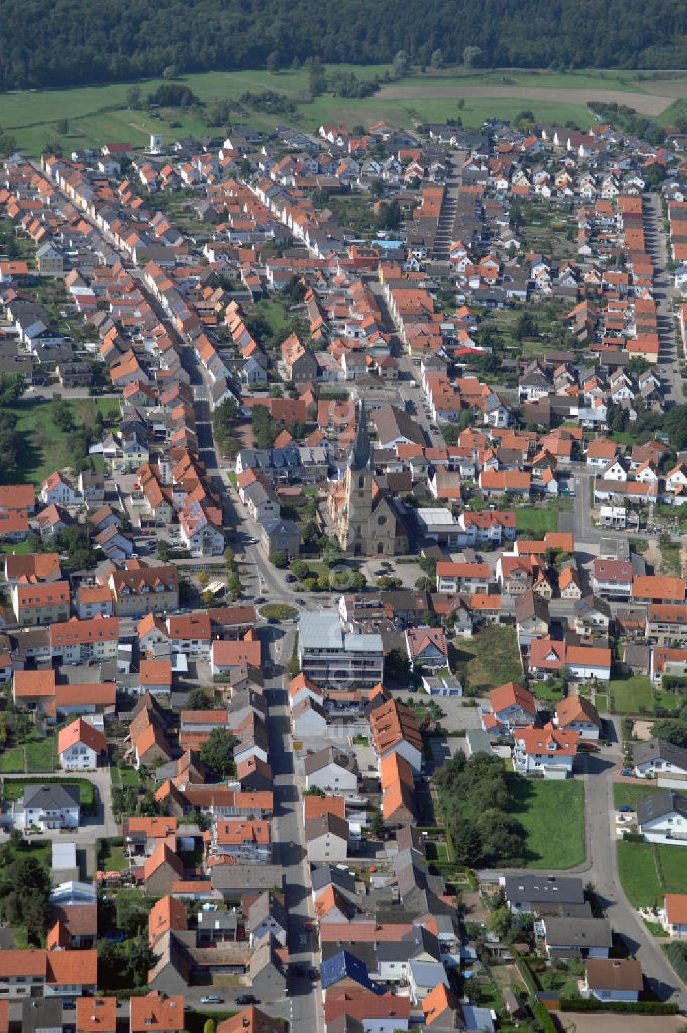 HAMBRÜCKEN from the bird's eye view: Blick auf die Pfarrkirche Hambrücken und das Wohngebiet entlang der Kirchstraße und der Rheinstraße. Hambrücken ist eine Gemeinde im Landkreis Karlsruhe in Baden-Württemberg. Hambrücken liegt in der Oberrheinebene westlich der Bundesautobahn 5, rund 10 km nord-nordwestlich von Bruchsal. Obwohl der Ort in kirchlichem Besitz war, wurde erst 1510 erstmals eine Pfarrkirche erwähnt. Diese Holzkirche wurde von Fürstbischof Damian Hugo von Schönborn durch eine massive Barockkirche mit Zwiebelturm ersetzt, die er 1742 selbst einweihte. Kontakt: Gemeinde Hambrücken, Hauptstr. 108, 76707 Hambrücken, Tel. +49 (0)72 55 71 00 0, Fax +49 (0)72 55 71 00 88, e-mail: gemeinde@hambruecken.de; Kontakt Katholisches Pfarramt: Pfarrer Armin Haas und Klaus Zöllner, Pfarrbüro: Frau Kretzler, Kirchstr. 2, Tel. +49 (0)7255 9410, Fax +49 (0)7255 6931