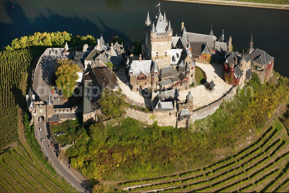 Aerial photograph Cochem - The Cochem Castle is a castle at the Mosel river in the Rhineland-Palatinate town of Cochem. After it had been destroyed in the 17th century, the businessman Louis Frédéric Jacques Ravené rebuilt the castle according to the taste of romanticism between 1868 to 1877. Today the castle is a museum and event space. The castle hill is used for winegrowing