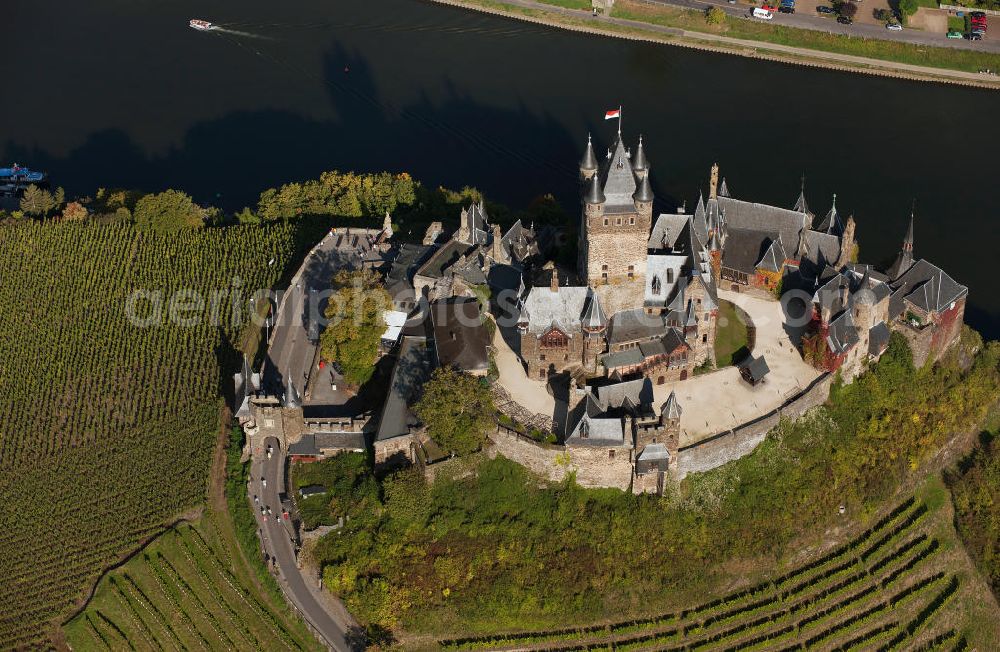 Cochem from above - The Cochem Castle is a castle at the Mosel river in the Rhineland-Palatinate town of Cochem. After it had been destroyed in the 17th century, the businessman Louis Frédéric Jacques Ravené rebuilt the castle according to the taste of romanticism between 1868 to 1877. Today the castle is a museum and event space. The castle hill is used for winegrowing