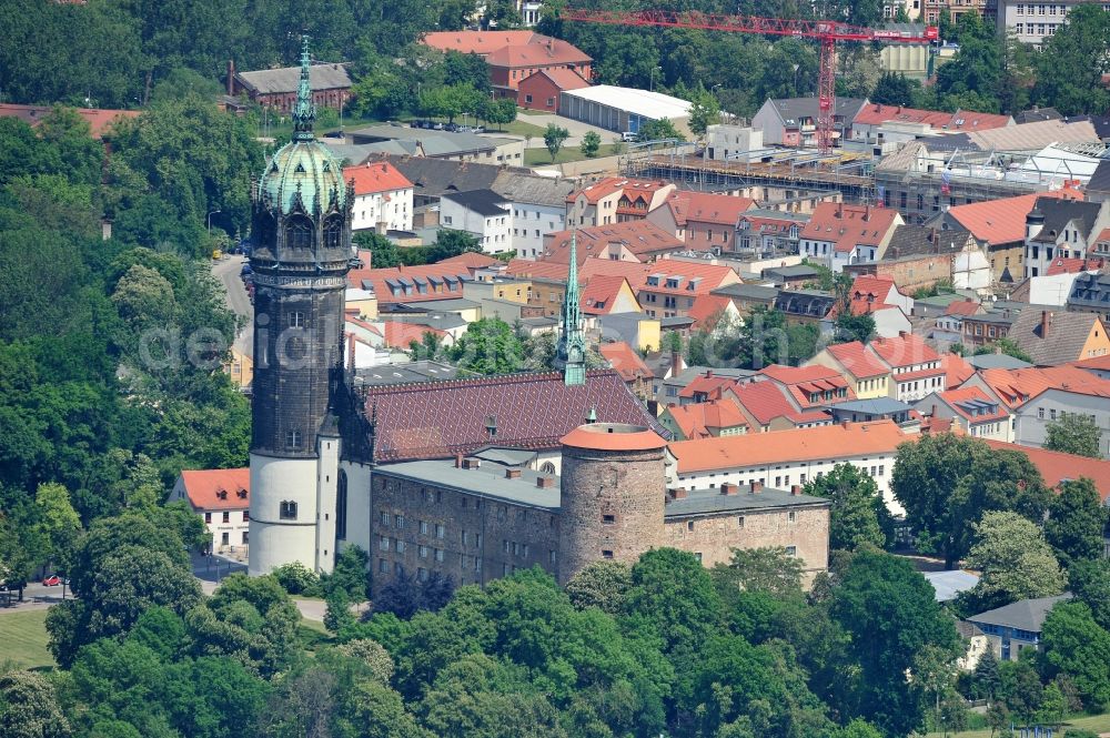 Aerial photograph Wittenberg - View of the castle church of Wittenberg. The castle with its 88 m high Gothic tower at the west end of the town is a UNESCO World Heritage Site. The first mention of the castle dates from 1187. It gained fame as in 1517 the Wittenberg Augustinian monk and theology professor Martin Luther spread his 95 disputation. Today, the castle is a hostel, the host of the Riemer Museum and of local history collections